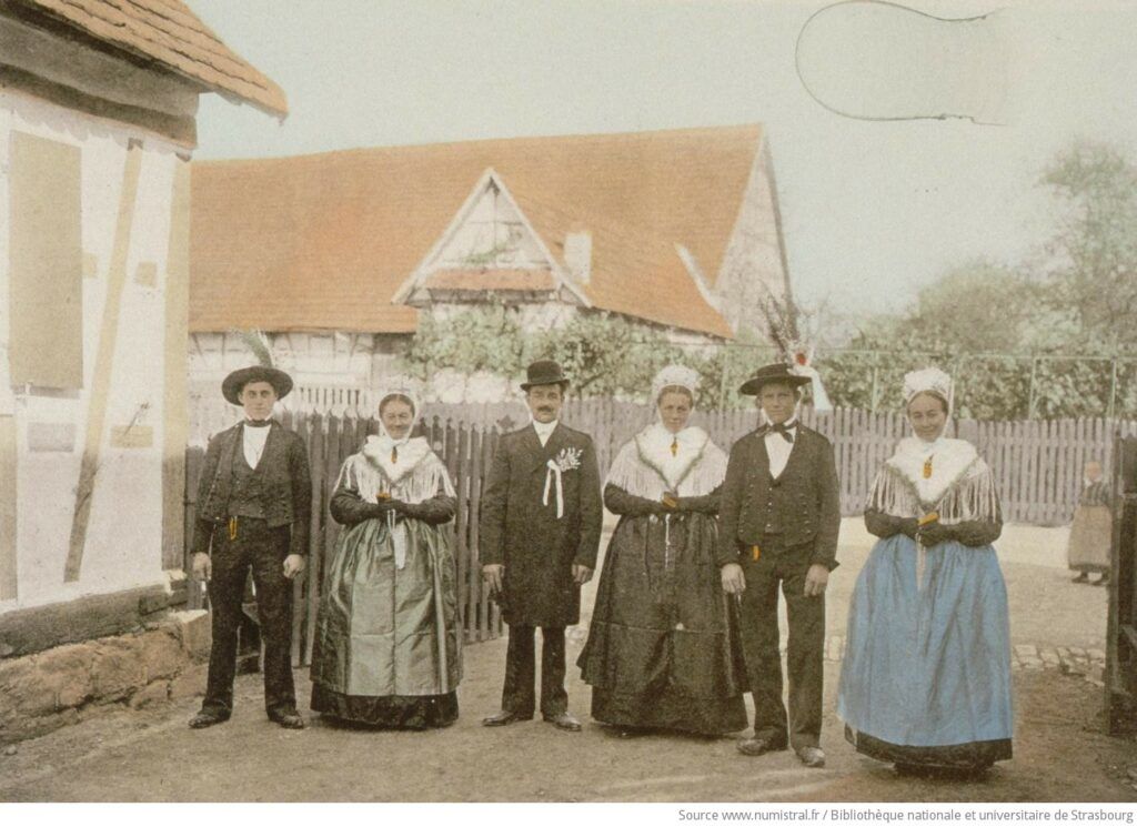 Après leur mariage, à Schleithal, un jeune couple et leurs ami·es posent devant l'objectif (1911)